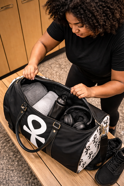 Open black Ankh duffle bag showing gym essentials, towel water bottle shoes, spacious travel and fitness bag