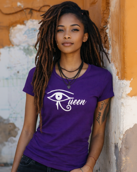 Woman wearing a purple t-shirt with 'Queen' design, standing against a textured wall.