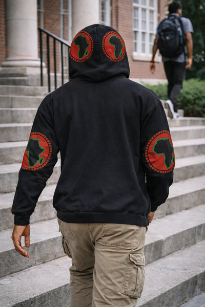 Person wearing a black hoodie with red and green designs on the back and arms, standing on steps.