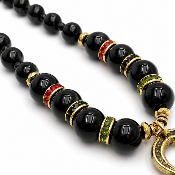 Black beaded necklace with gold and colored stone accents on a white background