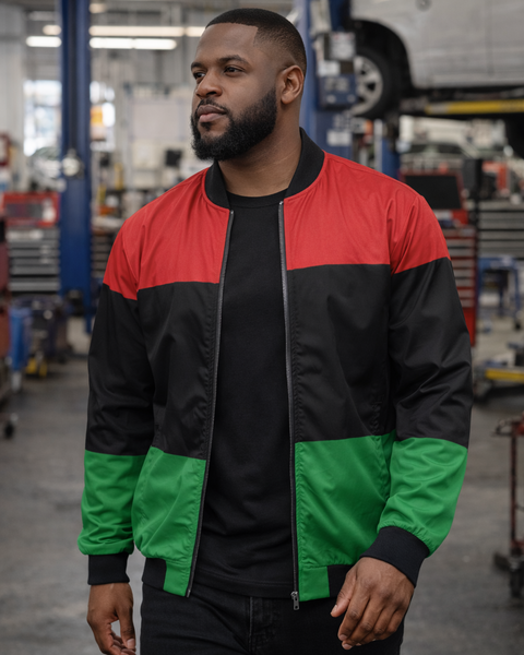 Man wearing a red, black, and green jacket in a workshop setting