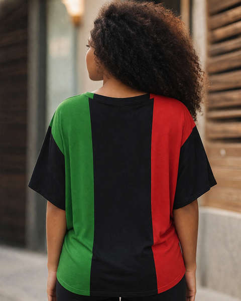 Person wearing a black, red, and green color-blocked shirt outdoors. PAN AFRICAN BATWING SHIRT BY NUBIAN LUXURIES BRAND