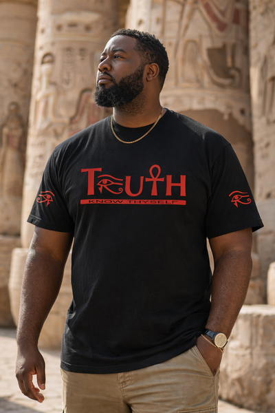 Man wearing a black t-shirt with red text standing in front of ancient Egyptian temple columns.