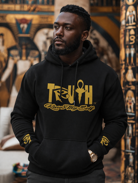 Man wearing a black hoodie with yellow text in an Egyptian-themed setting