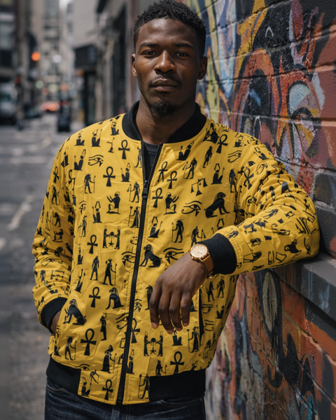 Man wearing a yellow jacket with black patterns standing in front of a colorful mural.